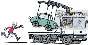 A man chasing tow truck as his car is hoisted onto flat bed.